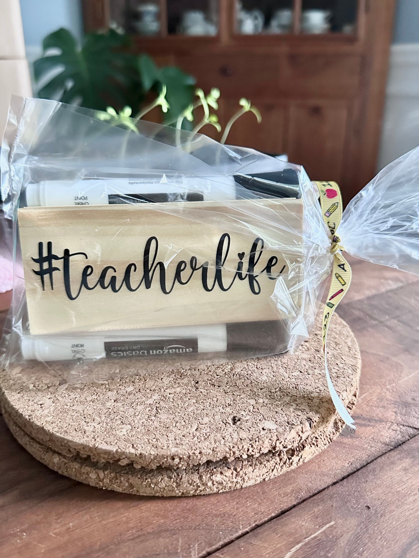 Packaged '#teacherlife' style teacher eraser kit placed on a cork trivet on a wooden surface